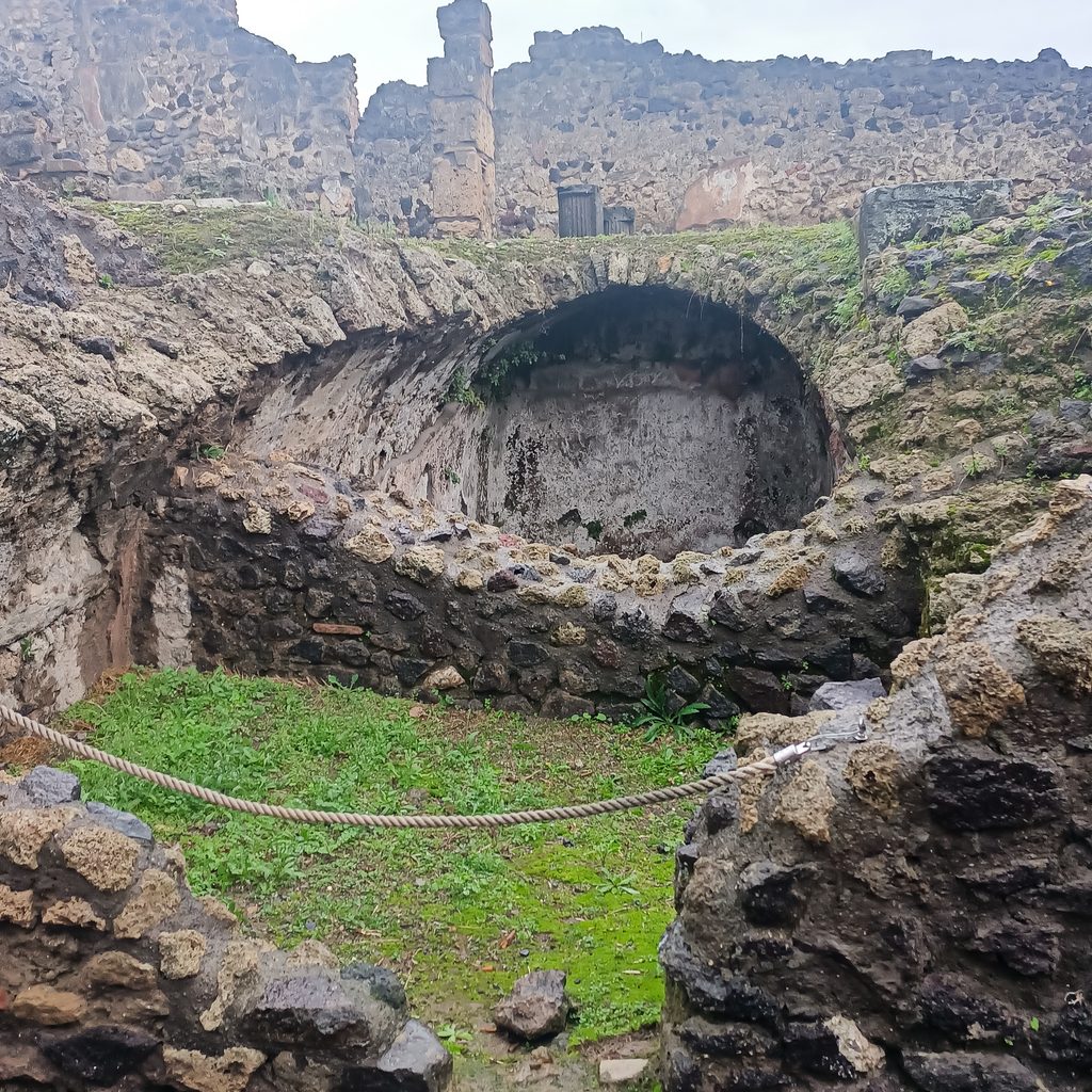 Pozostałości sklepionego pomieszczenia i kamiennych murów w starożytnych Pompejach