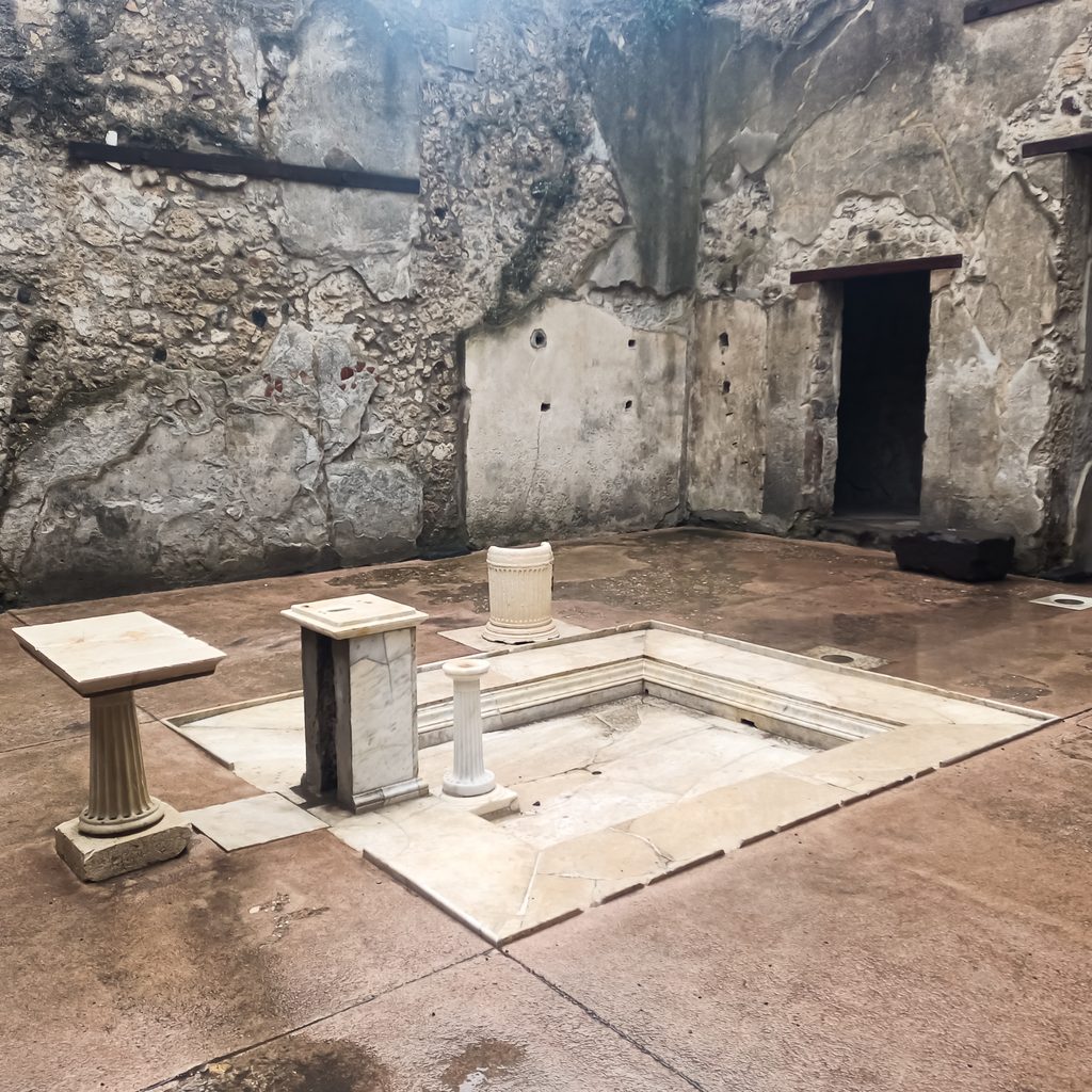 Impluvium w atrium jednego z domów w Pompejach z zachowanymi kamiennymi elementami wyposażenia