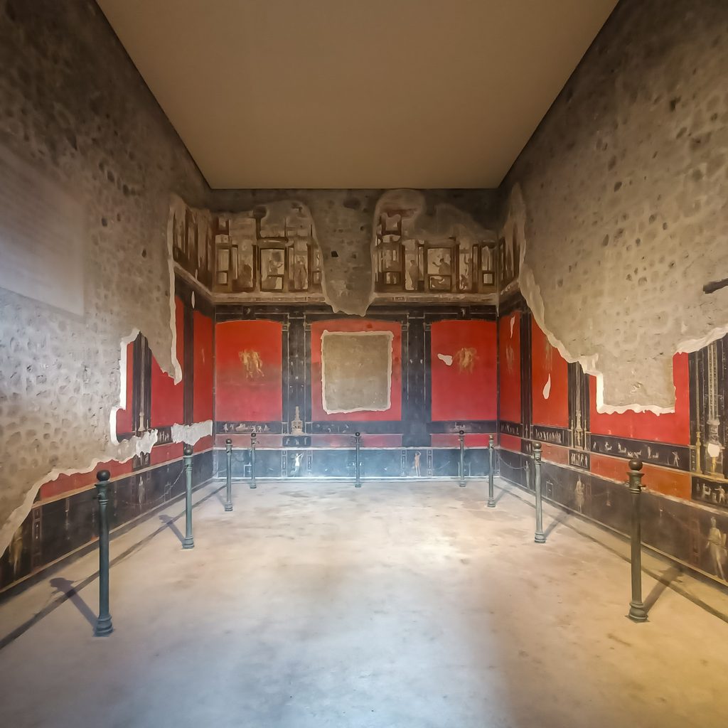 Wnętrze DOMU MENANDRA w Pompejach z zachowanymi czerwonymi freskami ściennymi