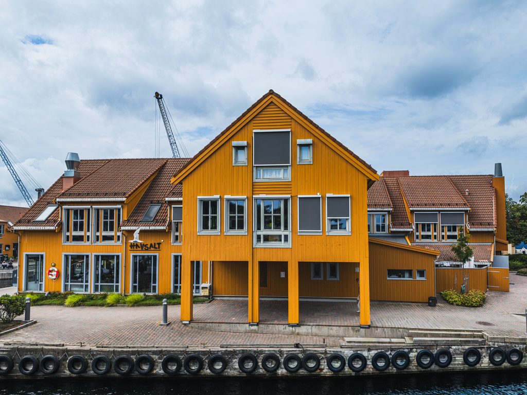 Żółty drewniany budynek przy nabrzeżu w Kristiansand, Norwegia.